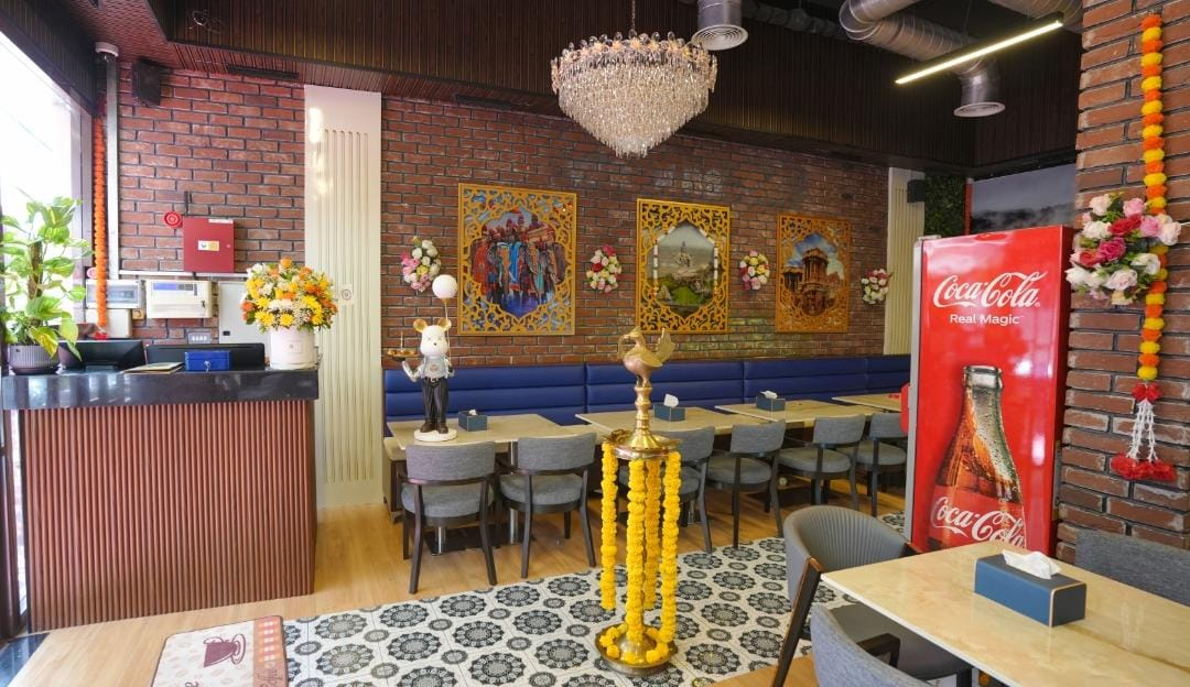 Chandelier-lit dining hall with traditional Indian artwork